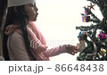 Cute little asia girl decorates the Christmas tree happy holidays concept 86648438