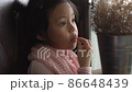 A little asia girl sitting on sofa chair is eating snack food concept 86648439