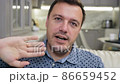 male sitting on sofa at home and saying goodbye to colleagues, finishing live video conference 86659452