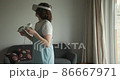 Woman in VR goggles playing game at home 86667971