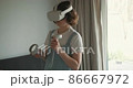 Woman in VR goggles playing game at home 86667972