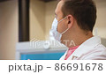 Doctor standing in laboratory and giving speech. Happy man in room with laboratory box in UV light 86691678