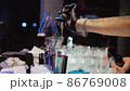 The bartender prepares a cocktail on the bar counter, close-up of the bartender's hands. 86769008