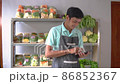 Man selling vegetables counting vegetables using calculator 86852367
