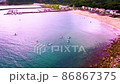 Women enjoying SUP at a campsite surrounded by the blue sea and forest 86867375