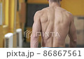 Muscular athletic man walks through the gym. View from the back. No face. Sport, weight lifting and health care concept  86867561