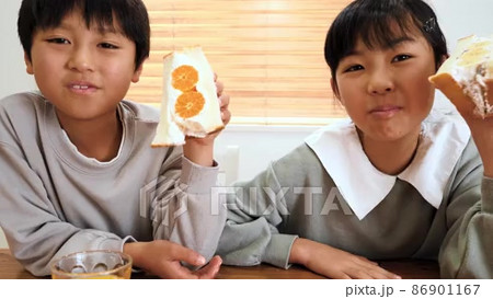 フルーツサンドを食べる小学生の女の子と男の子の動画素材