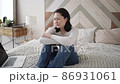 Upset young asian woman customer using laptop feel frustrated mad about computer problem, stressed about mistake software error, worried reading bad news in social media sit on couch at home 86931061