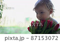 Cute little boy with a bouquet of tulips. Concept spring, holiday, gift. A gift for girls on female holiday with pink tulips. Mothers day 87153072
