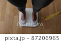 Woman Measuring Body Weight On Weighing Scale At Home 87206965