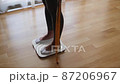 Woman Measuring Body Weight On Weighing Scale At Home 87206967