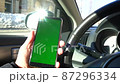 Phone with green screen in driver hand in car in slow motion 87296334