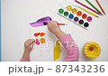 Cute adorable baby girl drawing with watercolor paints and brushes. Focused smart kid enjoying creative art hobby activity at home, children development concept 87343236
