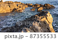 The sea waves beat against the shore rocks on sunny day. High-quality footage 87355533