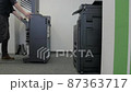 Technician sets up a multi-function copier device. 87363717