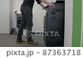 Technician sets up a multi-function copier device. 87363718