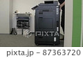 Technician dismantles a multifunction device. 87363720