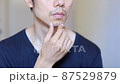 無精ひげを触る日本人男性 87529879