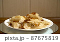 Ukrainian dumplings with fried onions on a plate. Continuous rotation on a movable stand. Fresh homemade dish. Seamless video 87675819