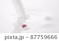 Raspberries and blueberries falling into the pouring milk flow or white cream  87759666