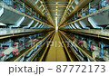 Large white chicken eggs are produced by laying hens sitting in huge cages under low light in a large poultry farm. 87772173