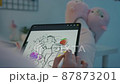 Female designer draws a sketch on a tablet pc 87873201