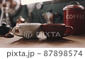 朝食で提供された2つのコーヒーカップと立ち込める湯気 87898574