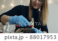 A woman cleans shoes in her apartment. Shoe cleaning, polishing, restoration with a brush and shoe care product 88017953