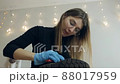 A woman cleans shoes in her apartment. Shoe cleaning, polishing, restoration with a brush and shoe care product 88017959