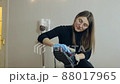 A beautiful young woman brushes her shoes before going to work. Shoe care at home 88017965