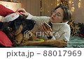 Young woman spend Christmas holidays at home with her pet on the bed with phone. Comfort, home, holidays 88017969