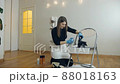 Woman spraying cleaning liquid on her shoes. Proper shoe care 88018163