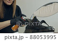 A beautiful girl takes care of shoes at home. Spraying shoes with a protective moisture-proof spray 88053995