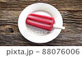 Melting fruit popsicle on white plate 88076006
