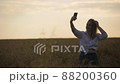 Cute young woman taking a selfie in the field 88200360
