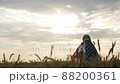 Patriotic young woman stands in a field wrapped in the US flag 88200361