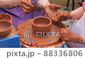 Hands of potter teaches the child how to make pots. Concept - transfer of experience, 88336806