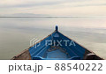 Blue boat sailing on a vast. Beautiful Kerkini Lake on a cloudy day. A mountain in the distance, soft neutral light. 88540222