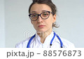Female doctor is putting off protective blue gloves isolated on white background after some medical manipulations, vaccination. 88576873
