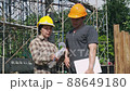 Construction manager and engineer discussing and checking plans on construction site. 88649180