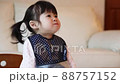 Girl happily eating baby food in the room 88757152