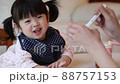 Girl happily eating baby food in the room 88757153