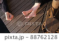 Relaxing on the pier on the shore during sunset, close-up of women's legs, friendly conversation 88762128