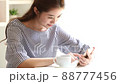 Young woman typing on her smartphone indoors 88777456