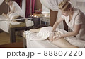 Professional female masseur doing anti-cellulite thigh massage for client at spa 88807220
