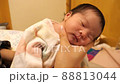 A 3-day-old baby girl rubs her back after breastfeeding 88813044