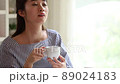 部屋でコーヒーを飲みながらくつろぐ若い女性の動画素材 [89024183]