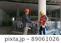 Engineer discussing with foreman about project in building construction site 89061026