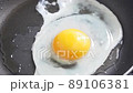 フライパンで目玉焼きを焼いている様子 89106381