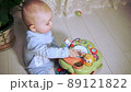 baby sits on floor and knocks on drum built into toy 89121822